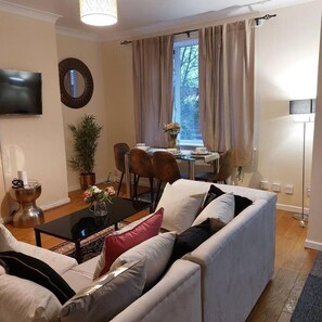 Ein Wohnzimmer mit einer Couch, einem Couchtisch und einem Essbereich mit Stühlen und einem Tisch.