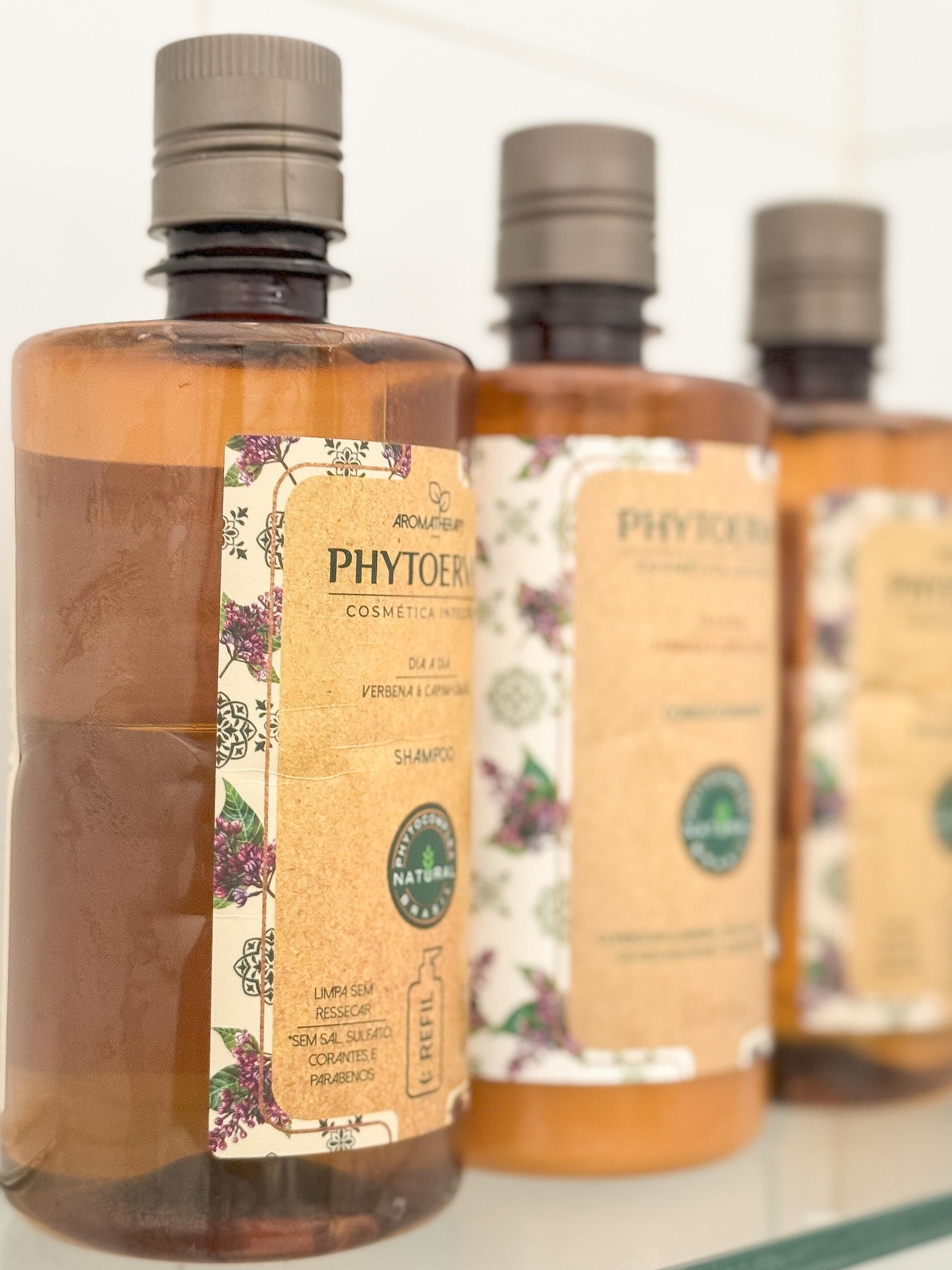 Trois bouteilles de shampoing cosmétique PHYTOERM, dont les étiquettes présentent des motifs floraux et le mot « NATUREL ».