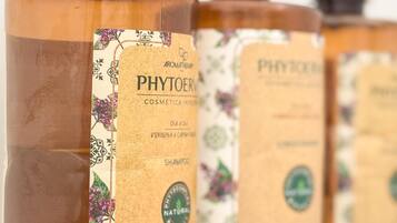 Three bottles of PHYTOERM cosmetic shampoo with labels featuring floral designs and the word "NATURAL".