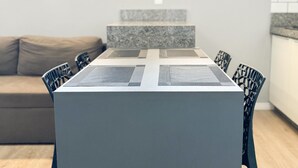Een moderne eetruimte met een rechthoekige tafel en zes stoelen.