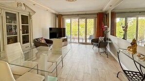 A spacious living room with a flat-screen TV, glass coffee table, and comfortable seating. - Comfortable and fully equiped two bedroom apartment (Cannes)