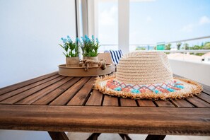 A wooden table with a woven hat and a small plant arrangement. - Narcissos Nissi Beach Apartment E9 (Ayia Napa)
