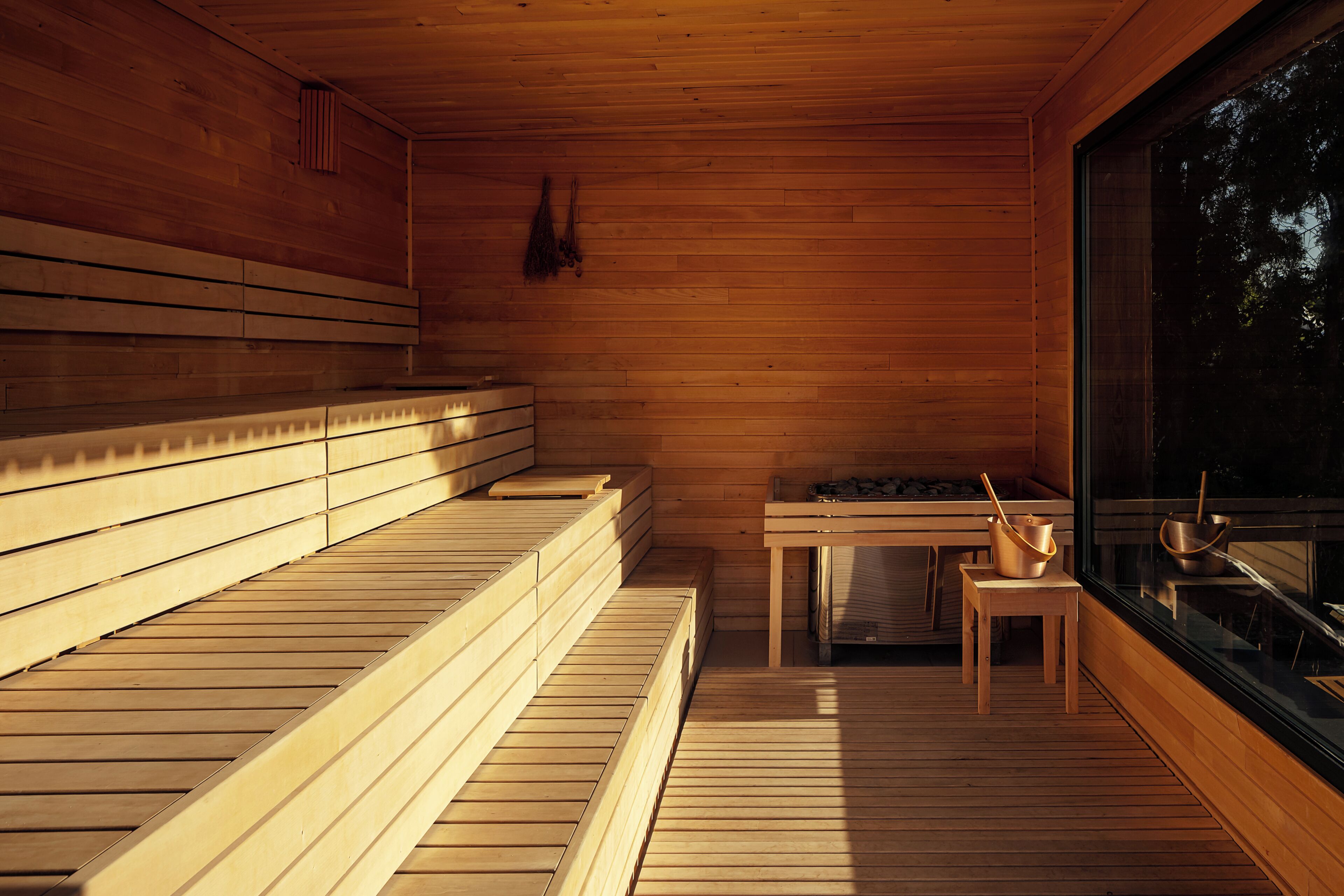 A sauna with wooden benches and a table with bowls.