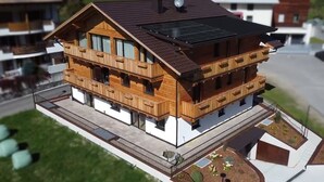 Ein Modell eines modernen Holzhauses mit Satteldach, Solaranlage und Balkon.