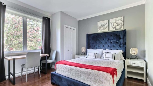 A bedroom with a bed, a desk, and a chair. - L'Artiste | Chic condo à Québec by Alchalet (Quebec)