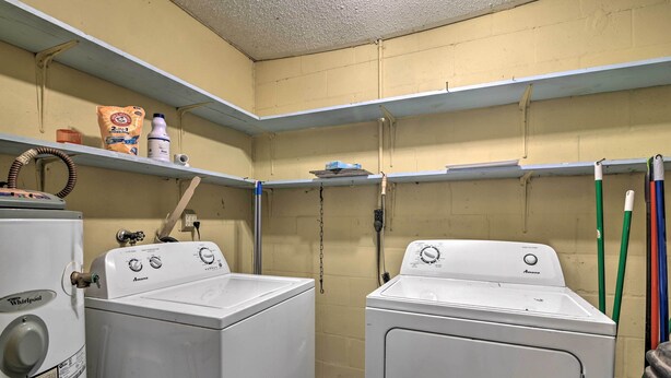 A laundry room with two Whirlpool washers, a shelf with cleaning supplies, and a broom. - Pet-friendly Brooksville Cottage w/ Fire Pit! (Brooksville)