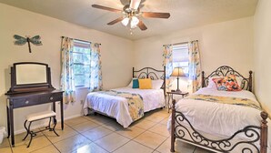 A bedroom with two beds, a vanity, and a ceiling fan. - Pet-friendly Brooksville Cottage w/ Fire Pit! (Brooksville)