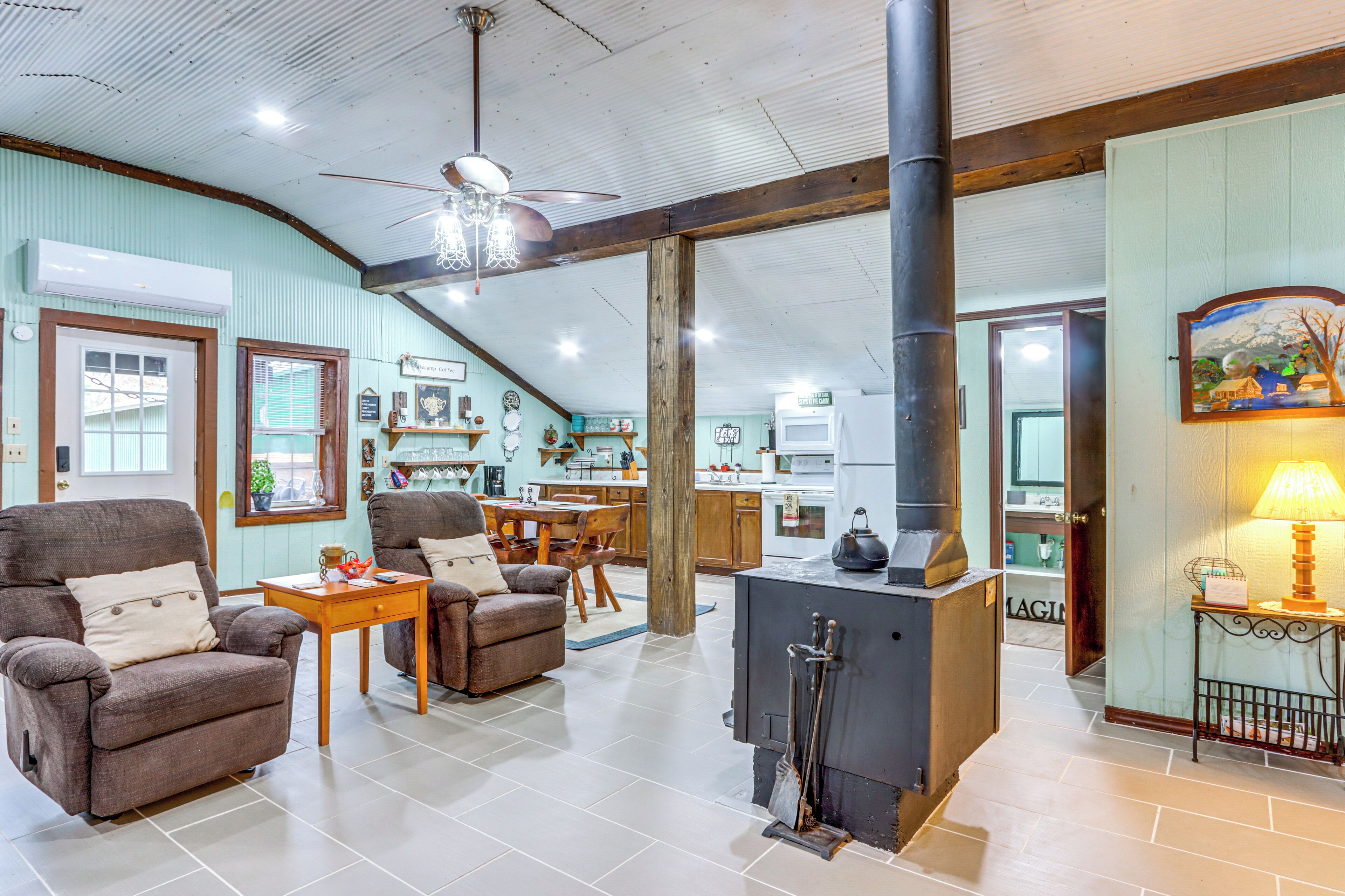 A spacious living area with a fireplace, a dining table, and comfortable seating.