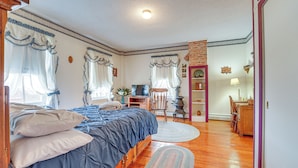 Ein Schlafzimmer mit Bett, Schreibtisch, Stuhl und Kommode.