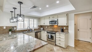 A modern kitchen with granite countertops, stainless steel appliances, and pendant lighting. - 6 Mi to TPC Scottsdale: Family Escape w/ Fire Pit! (Scottsdale)