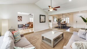 A spacious living room with a high ceiling, a ceiling fan, and a large window. - 6 Mi to TPC Scottsdale: Family Escape w/ Fire Pit! (Scottsdale)