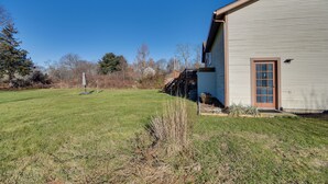 A single-story house with a front porch, a small front yard, and a clear blue sky. - Pet-friendly Narragansett Home w/ Deck + Gas Grill (Narragansett)