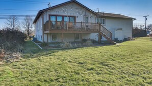 A two-story house with a balcony, a front porch, and a small front yard. - Pet-friendly Narragansett Home w/ Deck + Gas Grill (Narragansett)