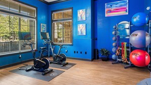 A gym with exercise bikes, a rowing machine, and a variety of exercise balls. - Fast WiFi, King Bed, Gym w/ Free Parking (Huntsville)