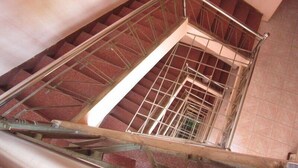 Una escalera con barandillas de metal y pasamanos de madera.
