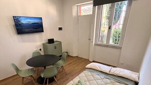 A room with a bed, a desk, and a chair. There is a window with a view of greenery. - Scappo in Umbria, Casaleo (Perugia)