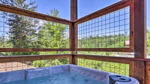 A hot tub with a wooden frame and a view of a forested area. - Wanderlust Pool Cabin: Private Pool, Hot Tub (Sevierville)