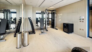 A modern gym with various exercise equipment, a mirror, and a motivational phrase on the wall.