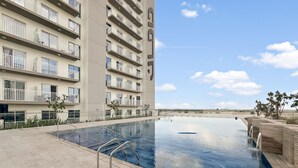 A swimming pool with a clear view of the surrounding buildings and a clear sky.