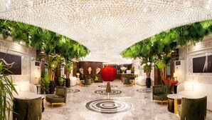 A luxurious lobby with a marble floor, green upholstered seating, and a large red spherical decoration. - TNR Otel & Spa (Kusadasi)