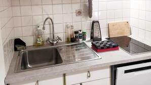 Una cocina con microondas, tostadora, lavamanos y horno empotrado.