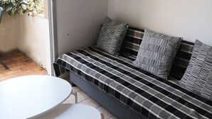 Una sala de estar moderna con un sofá, una mesita redonda y un cuadro enmarcado en la pared.