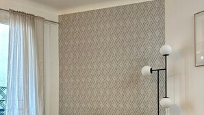 A cozy room with a sofa, a round table, a floor lamp, and a radiator. - Charming duplex apartment near Champs-Elysées (Paris)