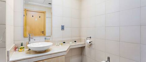 Un baño moderno con un lavamanos grande, un bidé y un espejo.