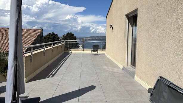 A balcony with a view of the sea, a chair, and a building with a light fixture. - Sète, Sunshine Lodge, Grande Villa familiale sur (Sète)