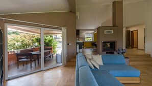A spacious living area with a sliding glass door leading to a balcony, a blue sofa, and a fireplace.