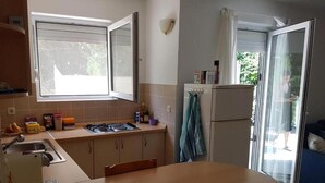 A kitchen with a stove, sink, and a dining table. - BlueSun
Two Bedroom Apartment with terrace  (Zaton)