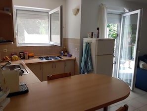 Keittiössä on liesi, pesuallas ja ruokapöytä.