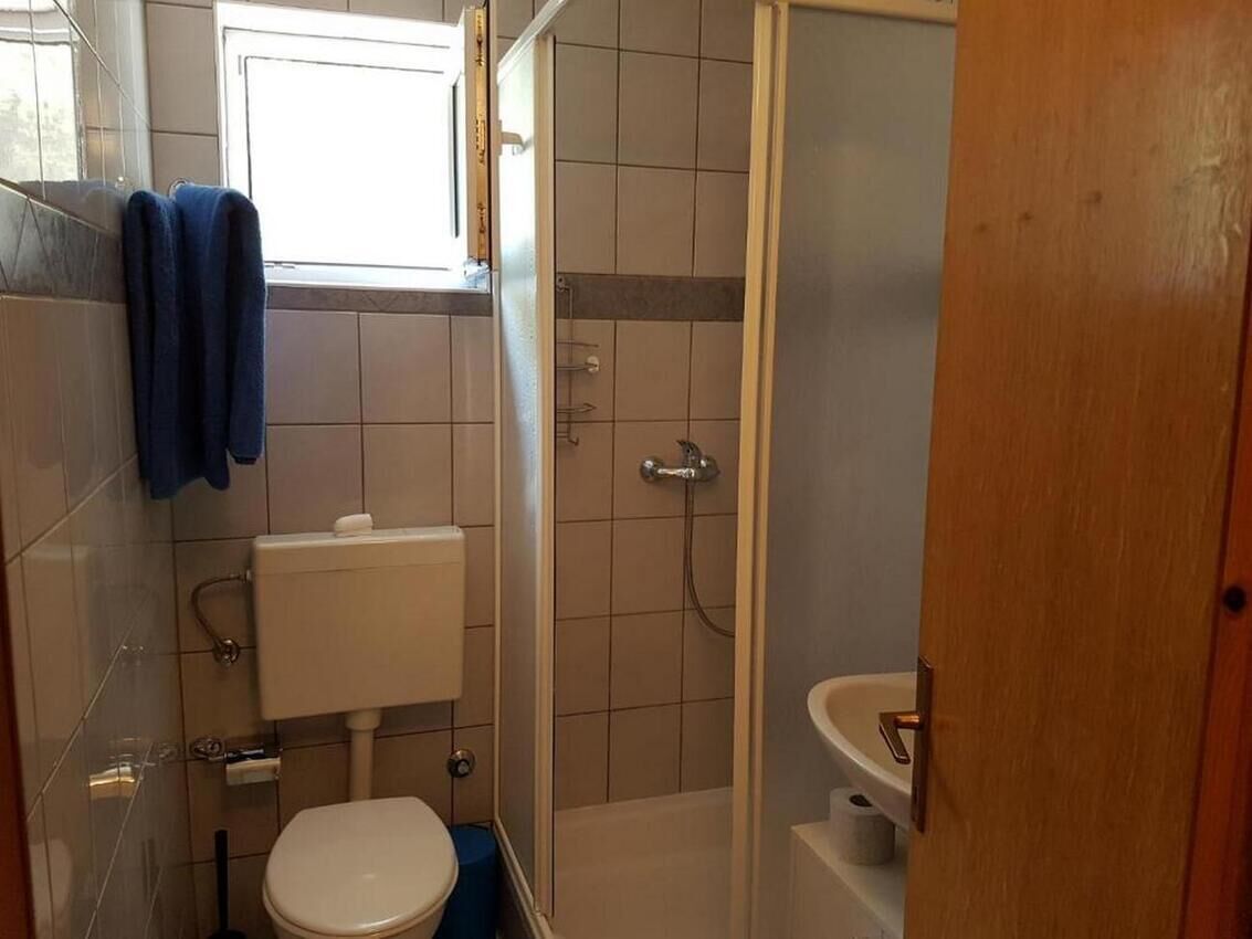 Un bagno piccolo con il water, un lavandino e una doccia.