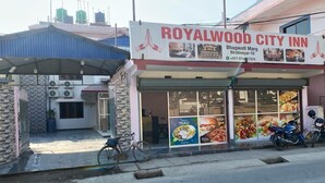 A Royalwood City Inn with a signboard advertising various dishes like Thai and pizza. - Royalwood City Inn (Biratnagar)