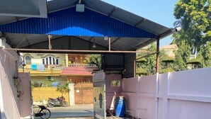 A covered outdoor area with a tiled floor, a metal gate, and a blue canopy. - Royalwood City Inn (Biratnagar)