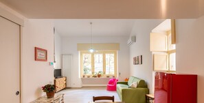 Una sala moderna con una mesa de comedor, un sofá y un refrigerador rojo.