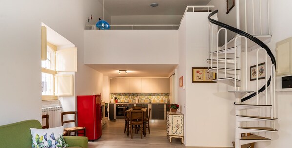 Un apartamento moderno con cocina, comedor y una escalera.