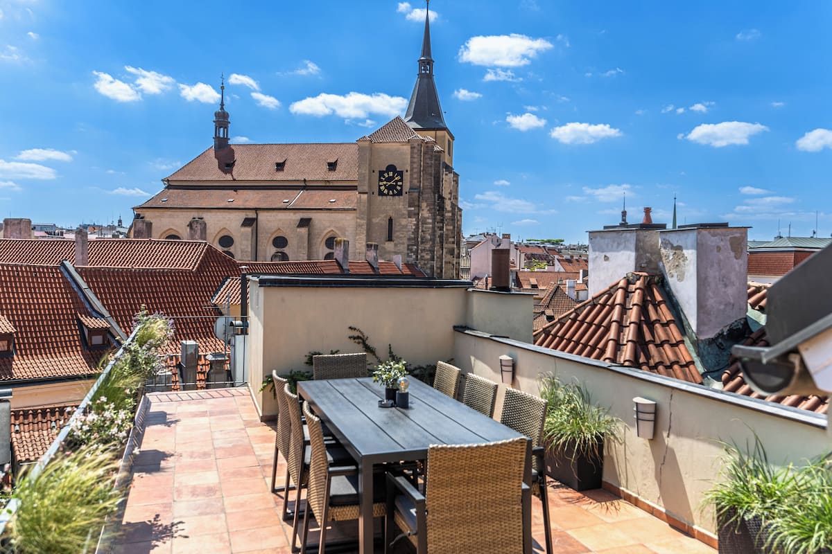 A rooftop terrace with a view of a church and surrounding buildings.