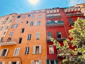 Un edifici d'alçades amb balcons i finestres.