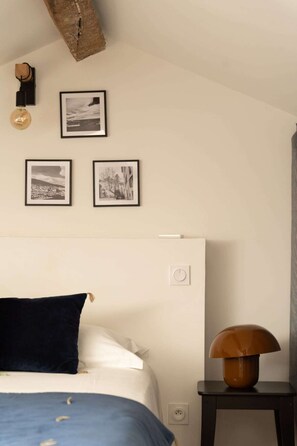 Un dormitorio con cama, mesita de noche y lámpara de pared.