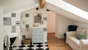 A modern bathroom with a black and white checkered floor, a white vanity with a mirror, and a blue cabinet. - Apartment Roof Top with spa (Bastia)