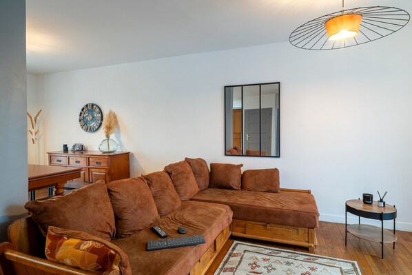 A modern living room with a brown sectional sofa, a wooden coffee table, and a small side table.