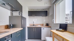 Una cucina moderna con mobili scuri, un forno a microonde, un tostapane e una macchina per il caffè.