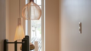 Una escalera con barandilla de madera y una lámpara colgante moderna.