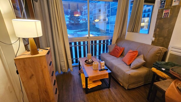 Un salon confortable avec un canapé, une table basse en bois et une lampe.