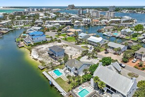 An aerial view of a coastal residential area with houses, a marina, and a beach. - 3BR Waterfront Modern Home with Canal Views, Pool + Boat Dock | Casa Palmas (Destin)