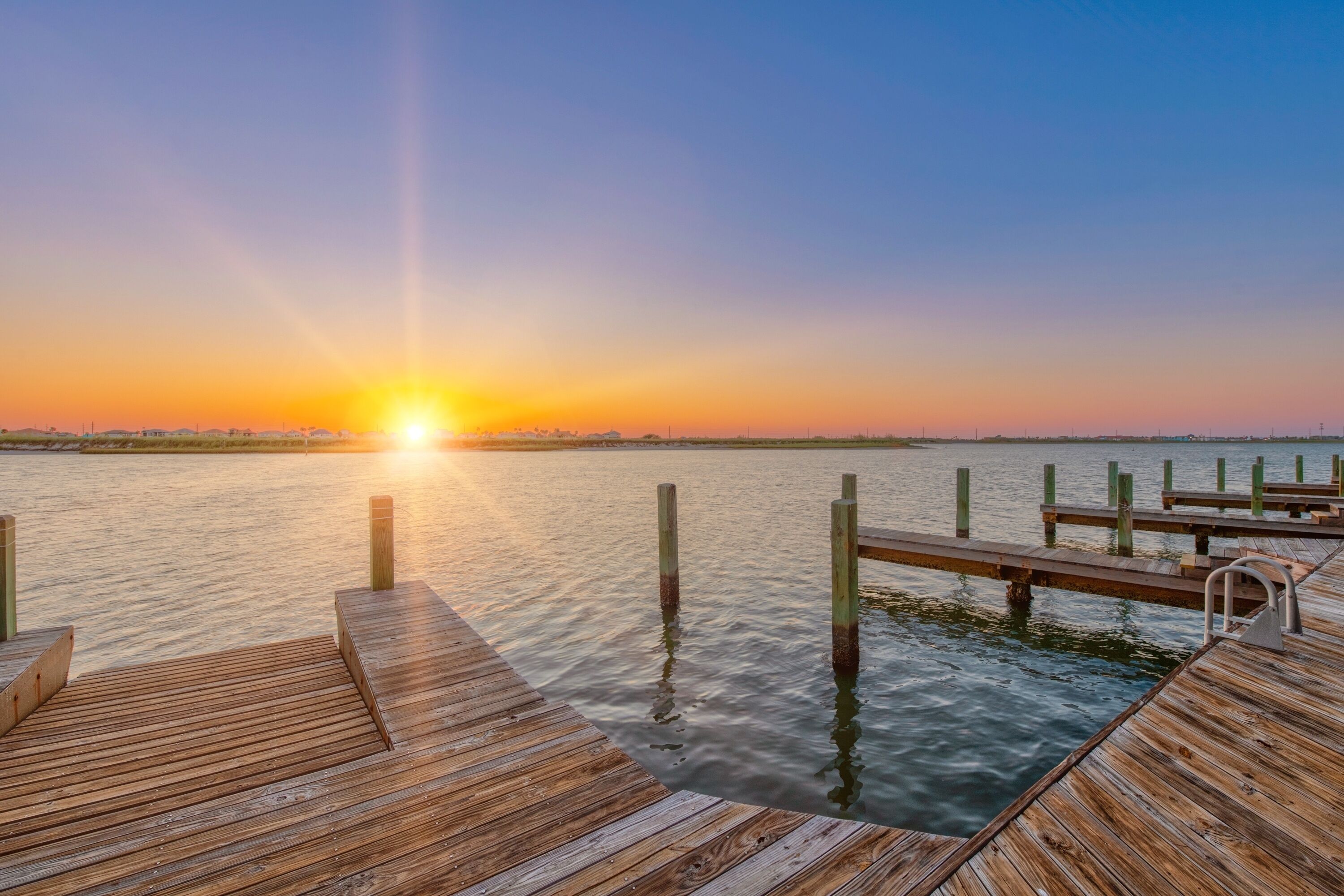 Un muelle de madera que se adentra en aguas tranquilas al atardecer.