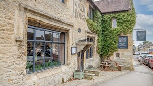 Un bâtiment en pierre avec une enseigne indiquant « The Porch House » et, au fond, une autre enseigne pour « Brakspear ».