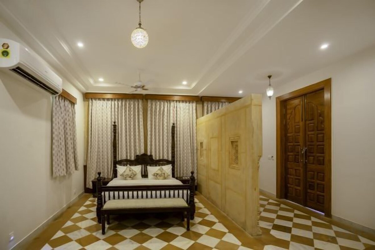 Un dormitorio con piso a cuadros, cama con cabecera de madera, cortinas y armario de madera.