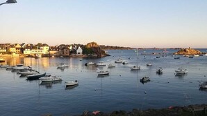 A harbor with numerous boats docked, a rocky coastline, and buildings along the shore. - Maison Ploubazlanec Pour 6 Personnes (Ploubazlanec)